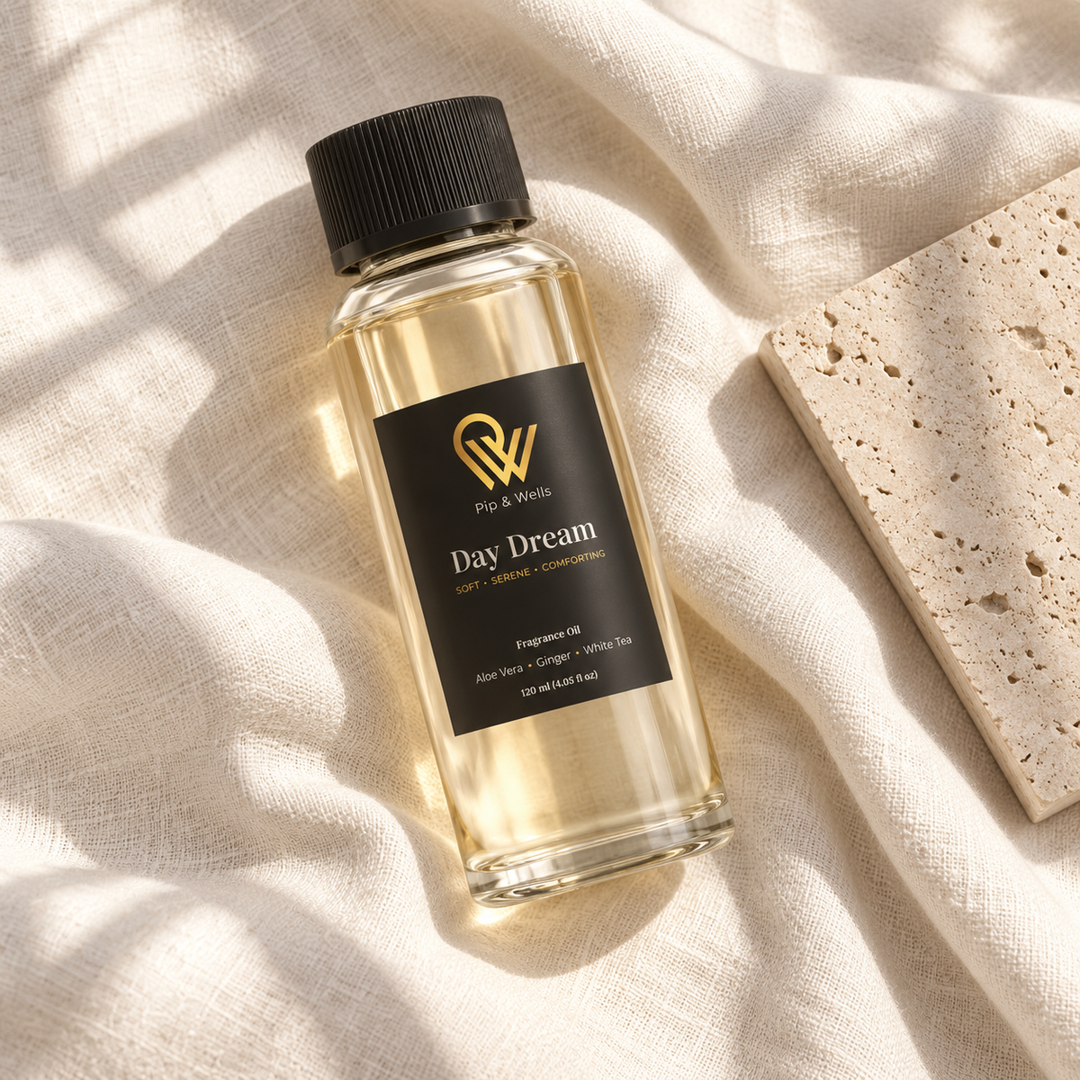 Frasco de aceite aromático Pip & Wells Day Dream de 120 ml sobre lino claro, junto a una baldosa de piedra texturizada