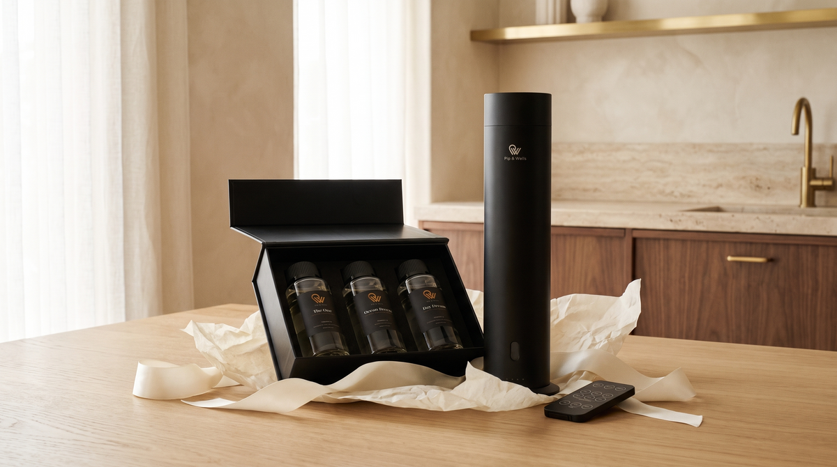 Set de regalo Pip & Wells sin envolver, con un difusor Pure One en acabado Matte Black y tres aceites aromáticos de hotel sobre una mesa de roble.
